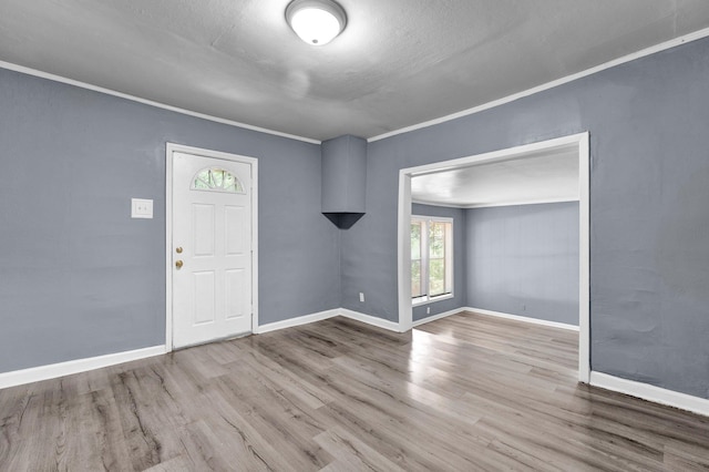 entrance foyer featuring hardwood / wood-style flooring, crown molding, and a textured ceiling