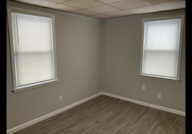 spare room featuring a drop ceiling and hardwood / wood-style floors