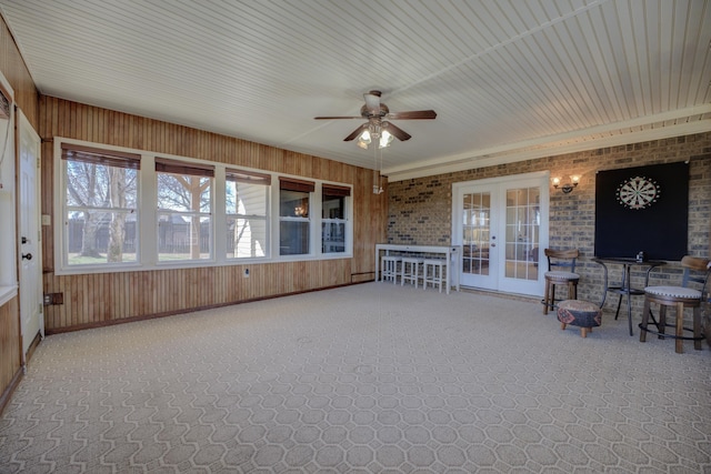 unfurnished sunroom featuring ceiling fan and french doors