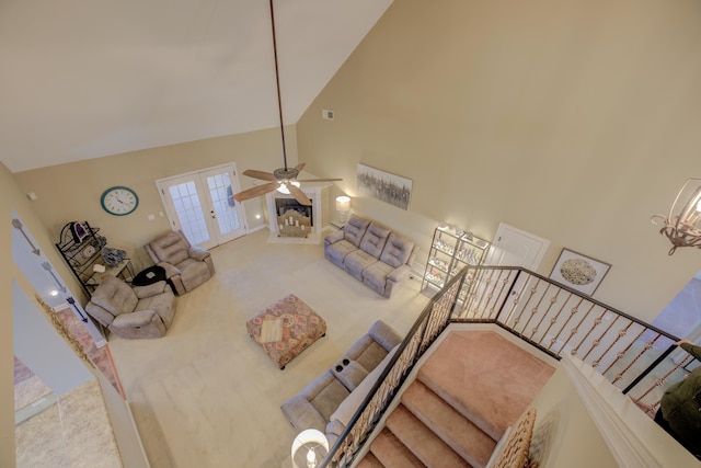 carpeted living room with french doors, ceiling fan, and high vaulted ceiling