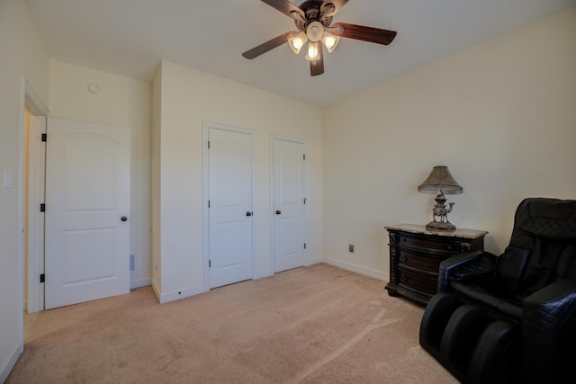 sitting room featuring light carpet and ceiling fan