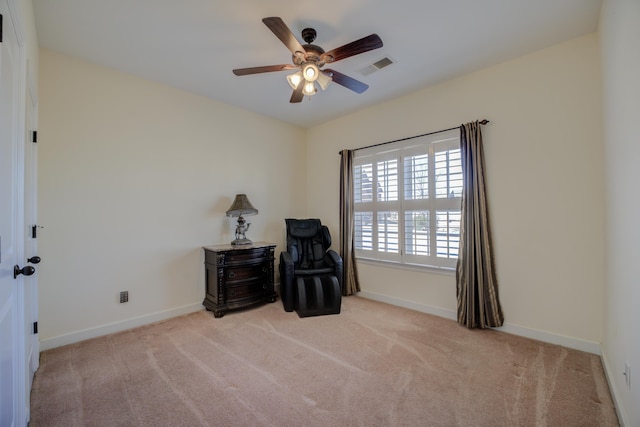 living area with light carpet and ceiling fan