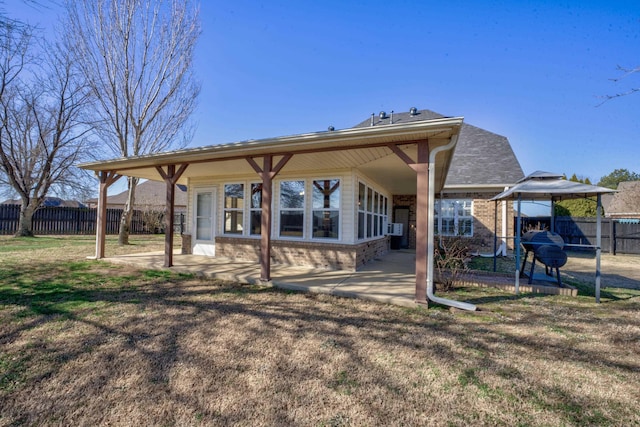 rear view of house with cooling unit, a gazebo, a lawn, and a patio