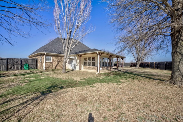 rear view of property featuring a lawn