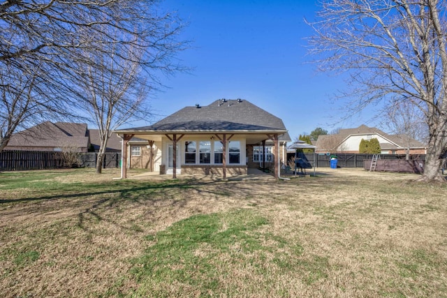 rear view of house featuring a yard and a patio