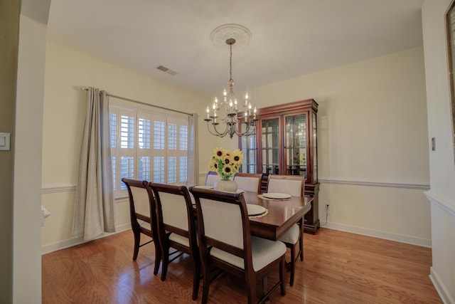 dining space featuring an inviting chandelier and light wood-type flooring