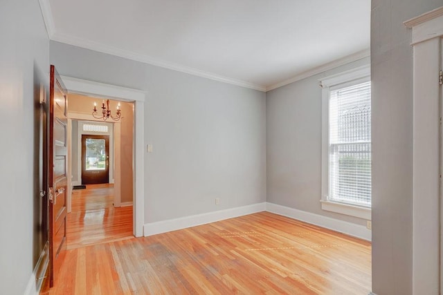 spare room featuring wood-type flooring, a healthy amount of sunlight, and ornamental molding