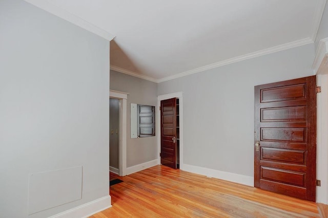 empty room with crown molding and light wood-type flooring