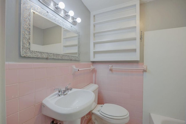 bathroom featuring tile walls, sink, a bathtub, and toilet