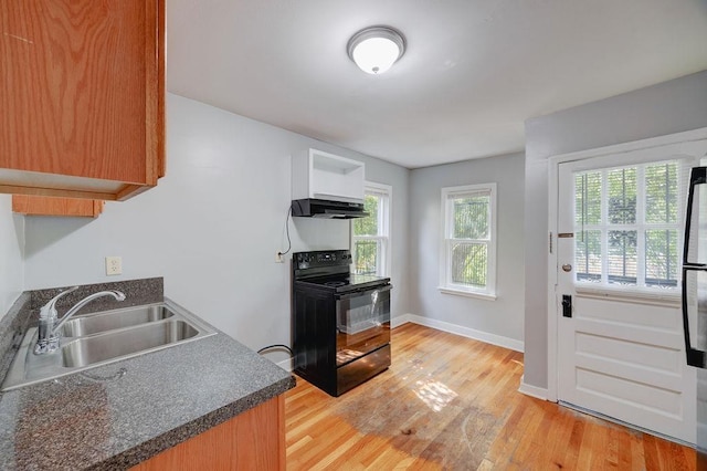 kitchen with plenty of natural light, sink, light hardwood / wood-style floors, and black / electric stove