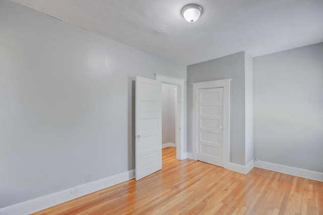 unfurnished bedroom with light hardwood / wood-style floors and a closet