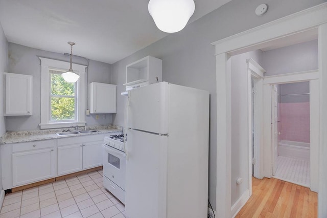 kitchen with decorative light fixtures, sink, white cabinets, light tile patterned floors, and white appliances