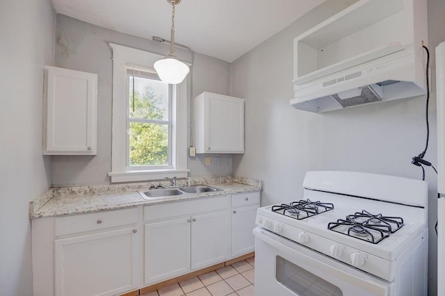 kitchen with white gas range, hanging light fixtures, and white cabinets