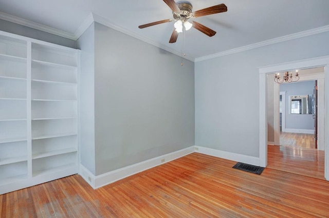 unfurnished room with ornamental molding, ceiling fan with notable chandelier, and hardwood / wood-style floors