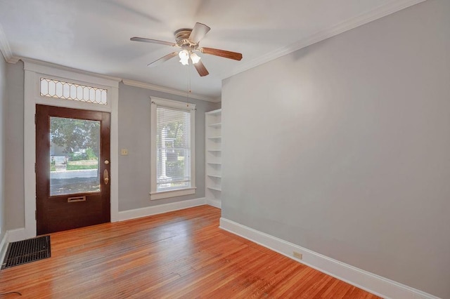 entrance foyer with hardwood / wood-style flooring, ornamental molding, and ceiling fan