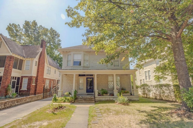 view of front of property featuring a front yard and covered porch