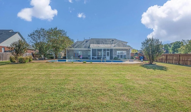 back of property with a fenced in pool, a lawn, and a patio