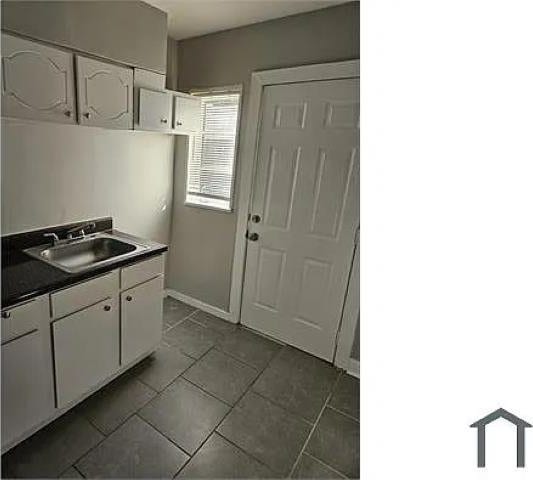 kitchen featuring sink and white cabinets