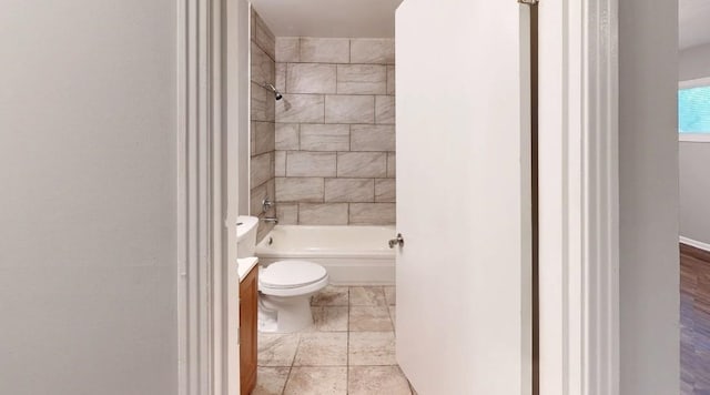 full bathroom featuring vanity, tiled shower / bath, and toilet