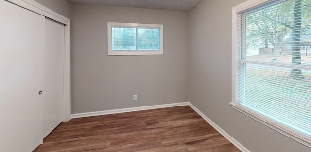 empty room with dark wood-type flooring and a textured ceiling