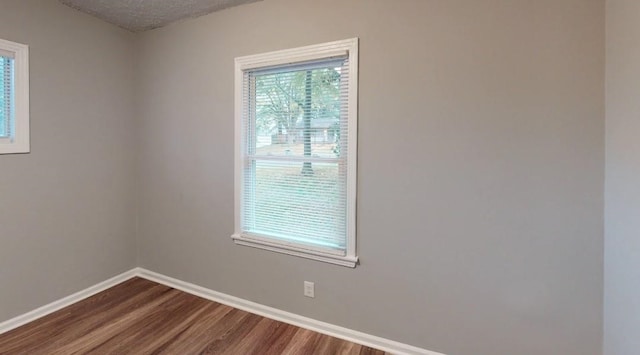 spare room featuring hardwood / wood-style floors and a textured ceiling