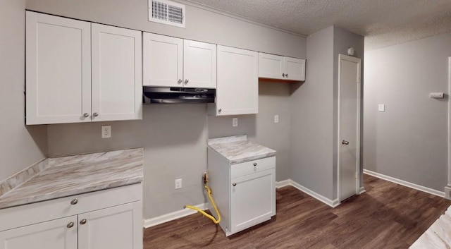 kitchen featuring white cabinetry, dark hardwood / wood-style floors, light stone counters, and a textured ceiling