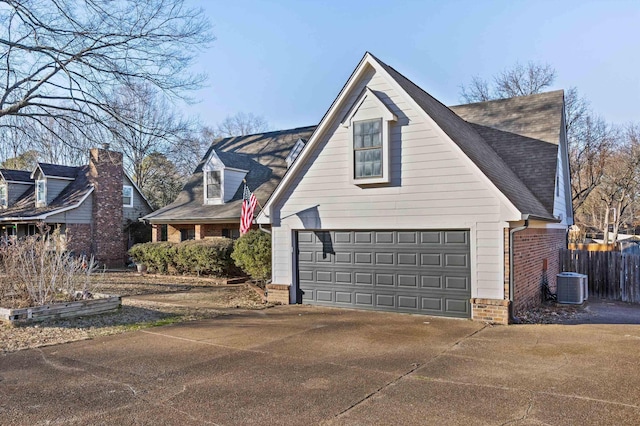 view of property exterior with cooling unit and a garage