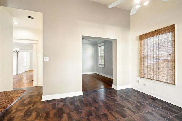 spare room with ceiling fan with notable chandelier