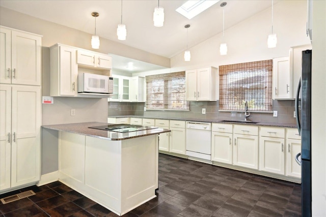 kitchen featuring decorative light fixtures, white cabinets, white appliances, and a skylight