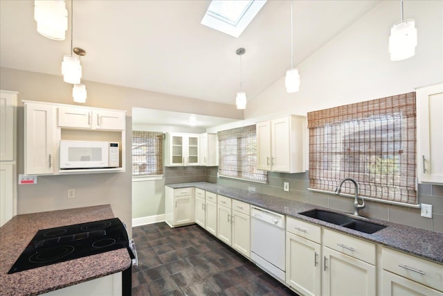 kitchen with sink, white appliances, white cabinetry, hanging light fixtures, and dark stone countertops