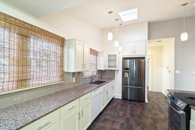 kitchen featuring sink, appliances with stainless steel finishes, white cabinetry, backsplash, and stone countertops