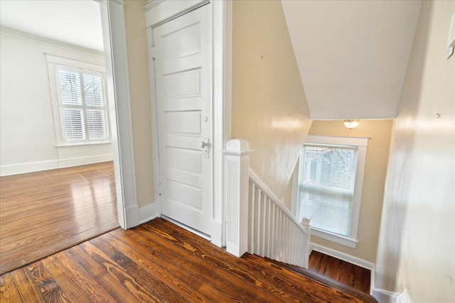 staircase with vaulted ceiling, a healthy amount of sunlight, and hardwood / wood-style floors