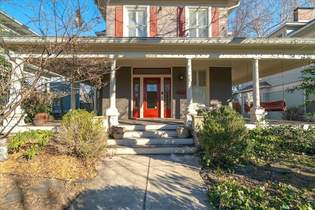 view of exterior entry featuring covered porch