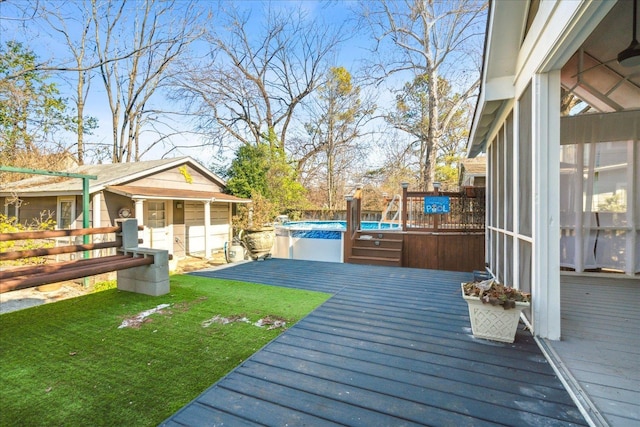 deck featuring a sunroom and a yard