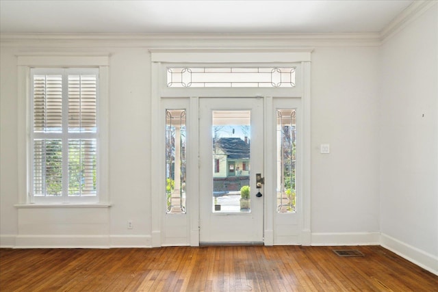 foyer entrance featuring crown molding, hardwood / wood-style flooring, and a wealth of natural light