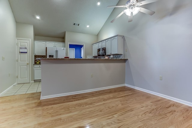 kitchen featuring light hardwood / wood-style floors, kitchen peninsula, and refrigerator with ice dispenser