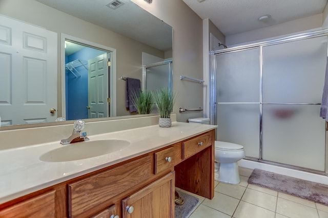 bathroom featuring tile patterned flooring, vanity, toilet, a shower with door, and a textured ceiling