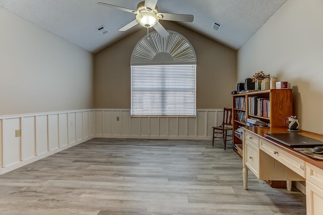 unfurnished office with ceiling fan, lofted ceiling, a textured ceiling, and light wood-type flooring