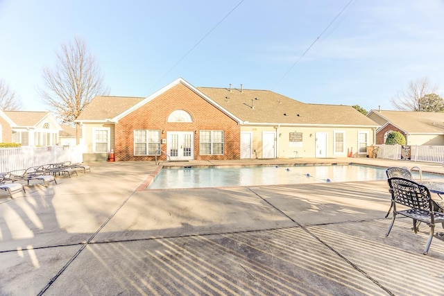 view of swimming pool with a patio and french doors