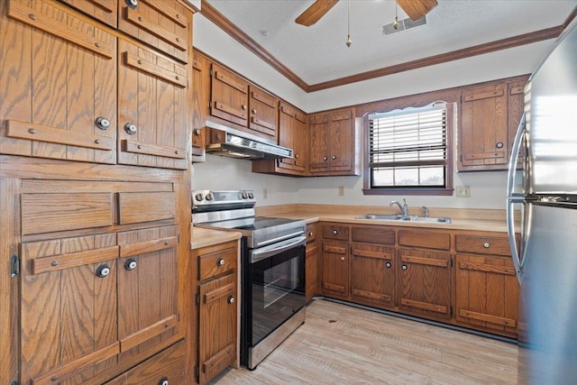 kitchen with sink, light hardwood / wood-style floors, stainless steel appliances, crown molding, and a textured ceiling