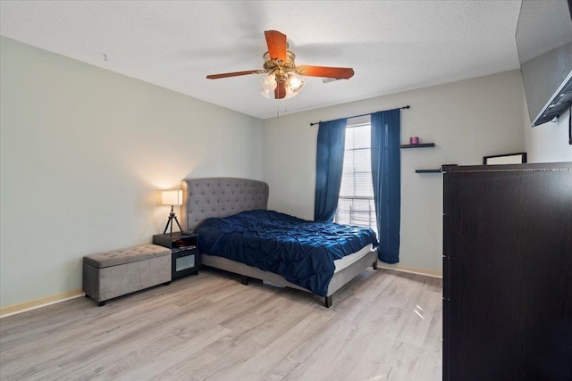 bedroom featuring a textured ceiling, ceiling fan, and light wood-type flooring