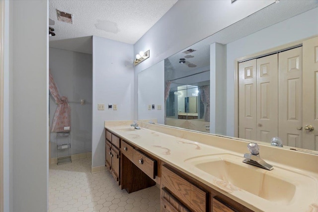 bathroom with vanity, tile patterned flooring, and a textured ceiling