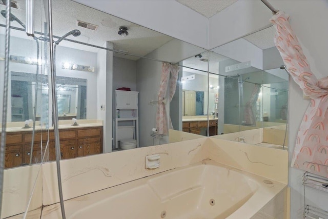 full bathroom featuring independent shower and bath, vanity, a textured ceiling, and toilet