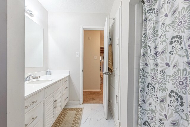 bathroom with vanity, a textured ceiling, and walk in shower