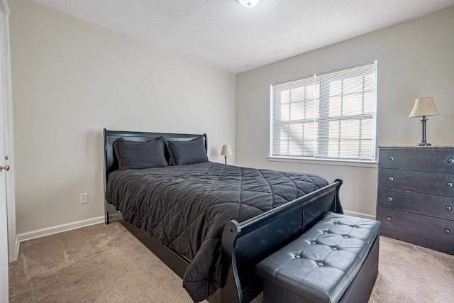 bedroom featuring light carpet and a textured ceiling