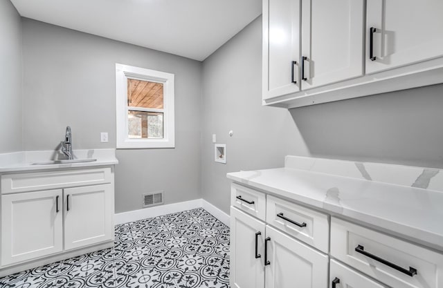 laundry area featuring washer hookup, sink, and cabinets