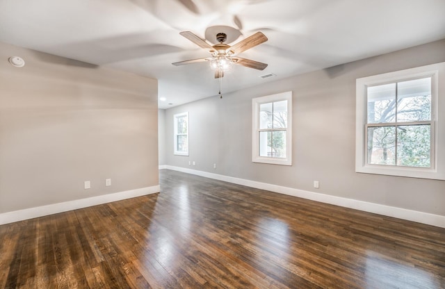 empty room with ceiling fan and dark hardwood / wood-style flooring