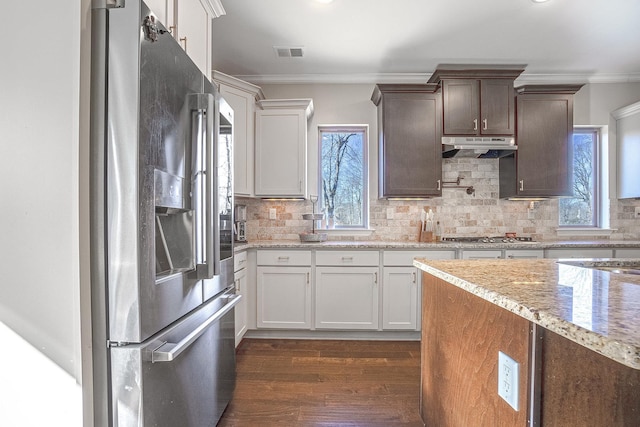 kitchen with dark wood-type flooring, white cabinetry, stainless steel appliances, tasteful backsplash, and ornamental molding