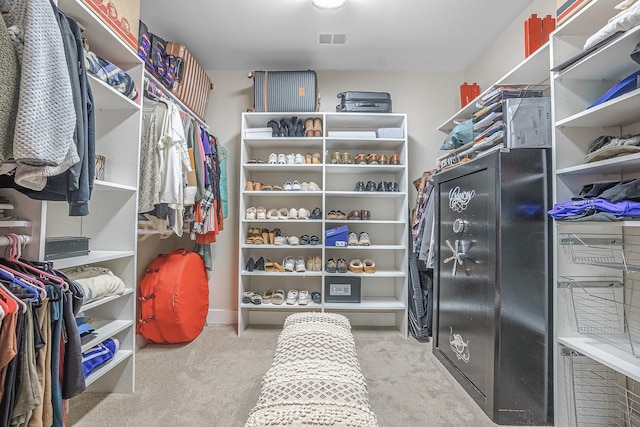 walk in closet featuring light colored carpet