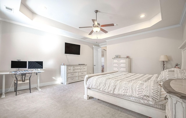 bedroom with ceiling fan, ornamental molding, a raised ceiling, and light carpet